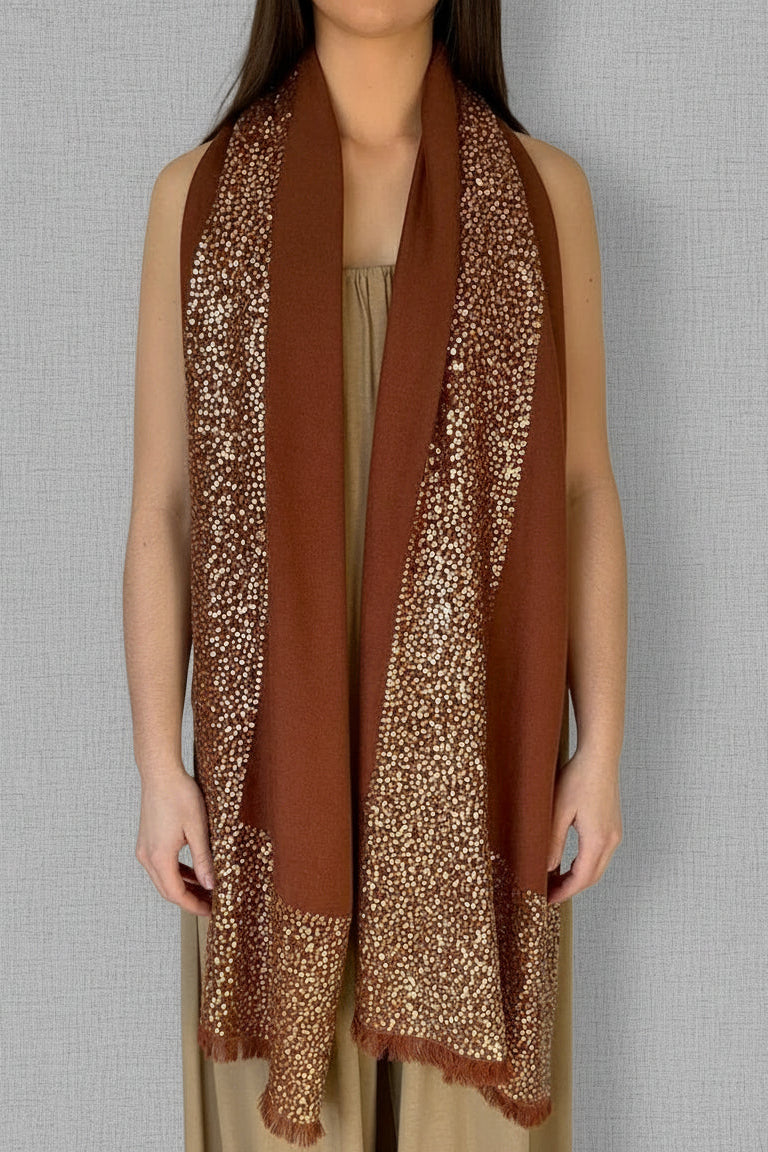 model in brown sparkle cashmere sequin scarf against a wall