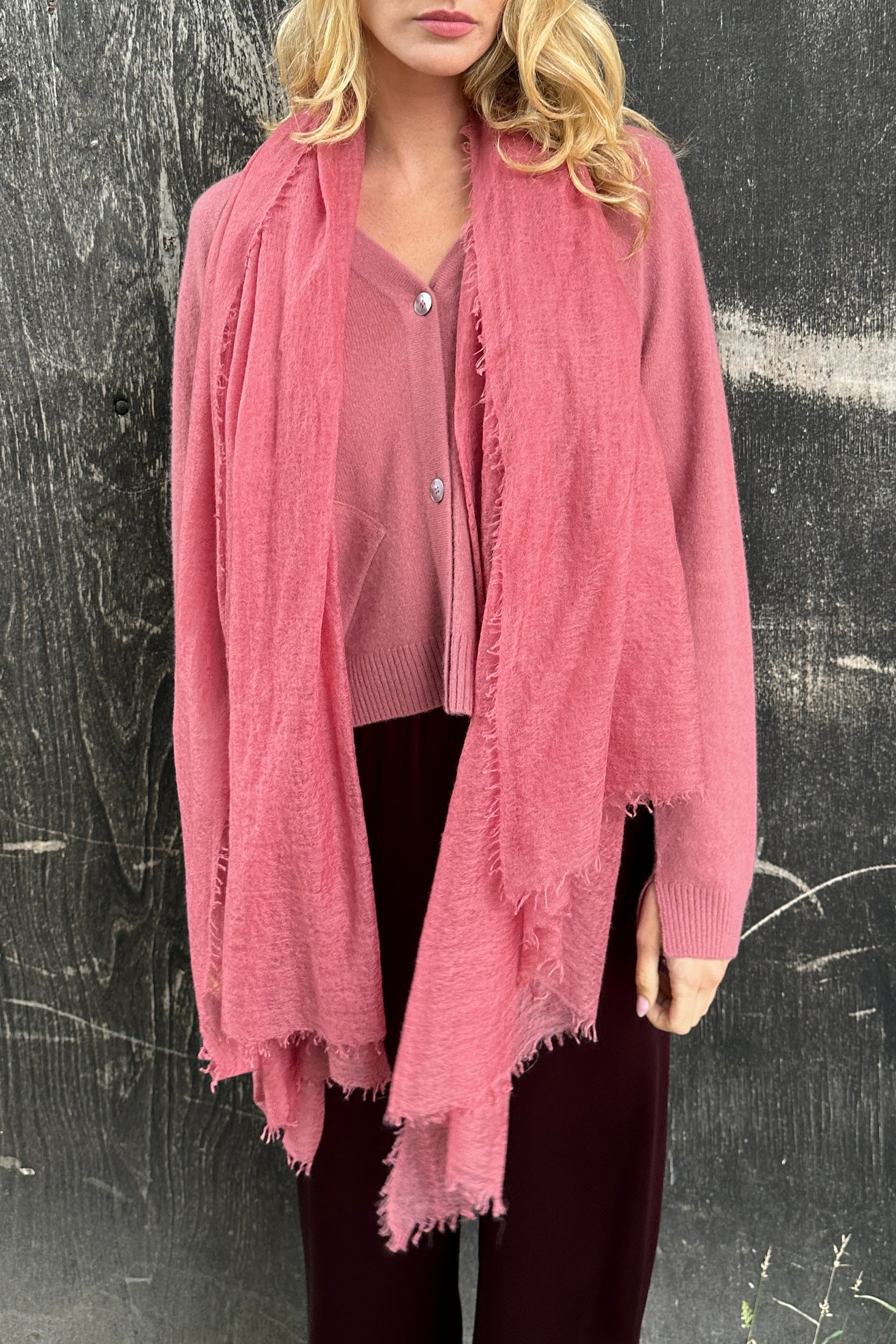 model wearing a pink cardigan over a pink top against a black marmee khalo rose pink cashmere scarf