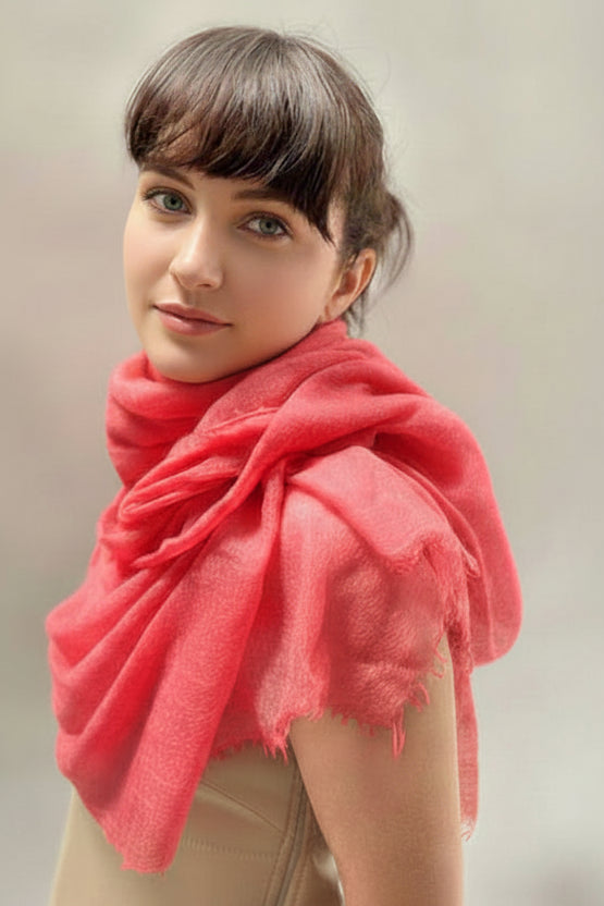 Woman wearing a pink scarf against a neutral background
