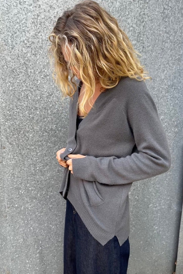 model wearing a zola grey gray cardigan against a textured wall