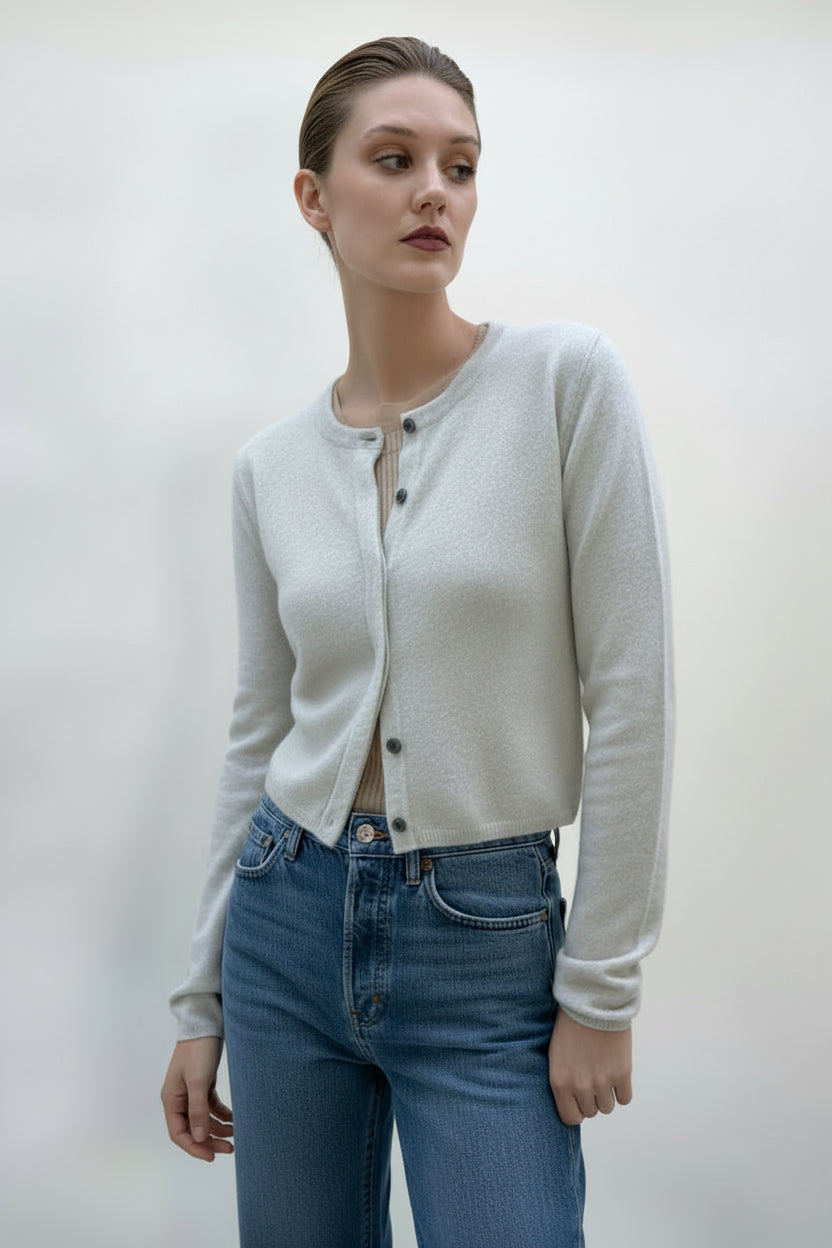 Woman wearing a cream-colored cardigan and pants against a white background