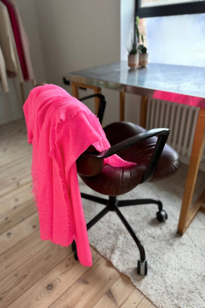 neon pink marmee scarf on a chair