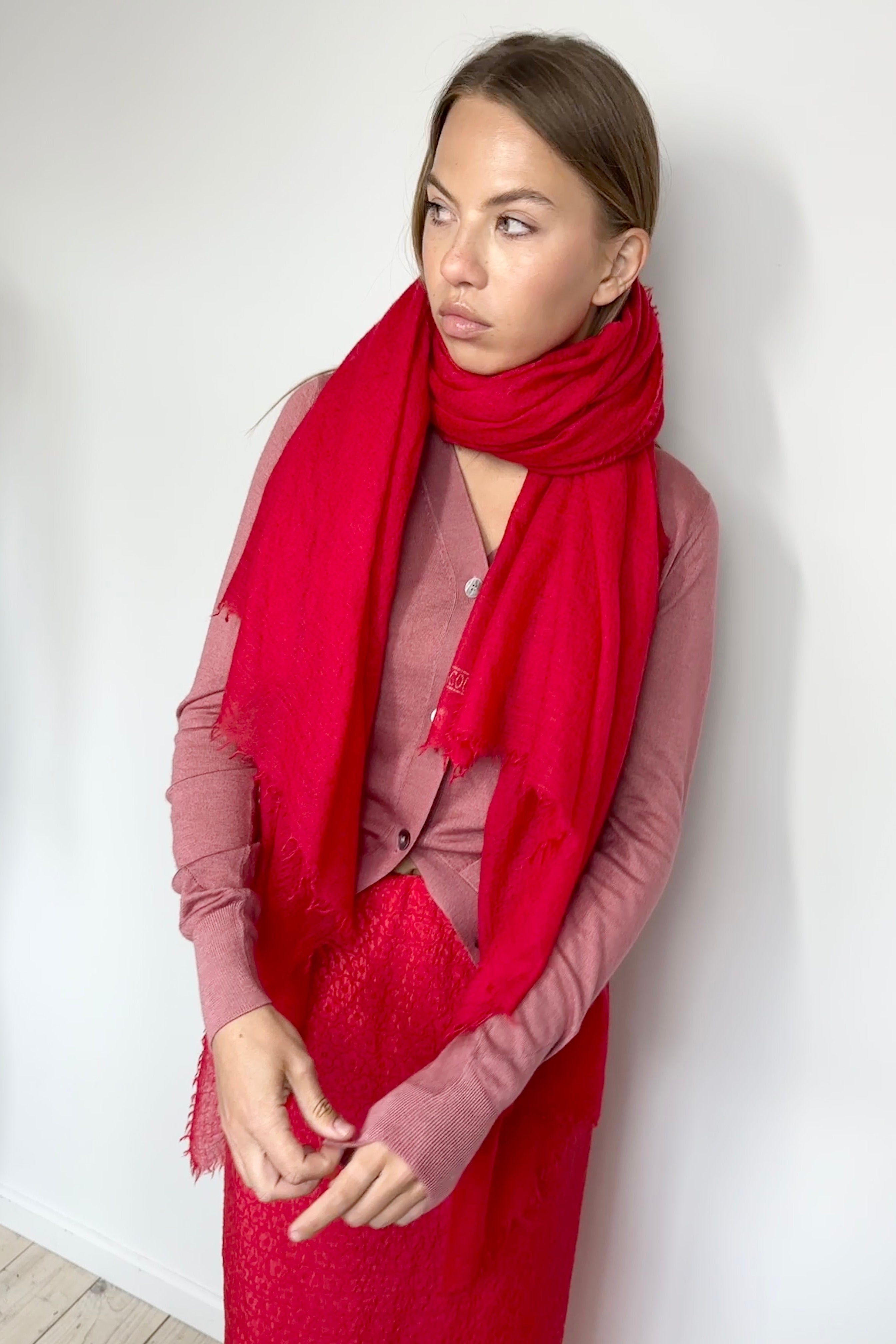 Woman wearing a red scarf and dress against a white background