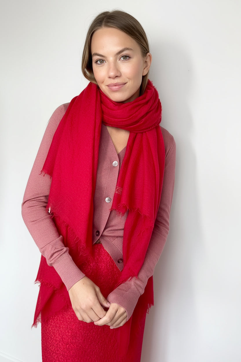 Woman wearing a red scarf and dress against a white background