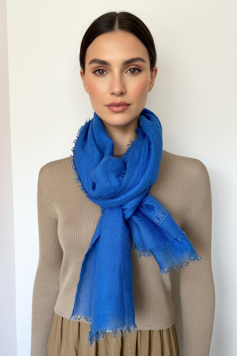 Woman wearing a blue scarf against a plain background