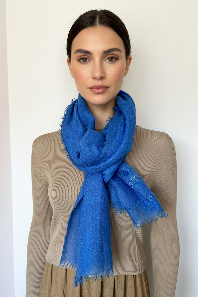 Woman wearing a blue scarf against a plain background