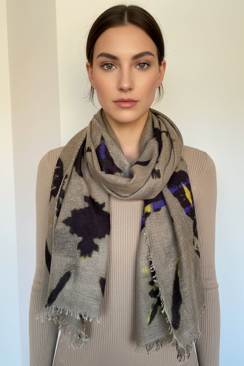 model wearing a beige scarf with dark brownand purple ikat patterns on a plain background