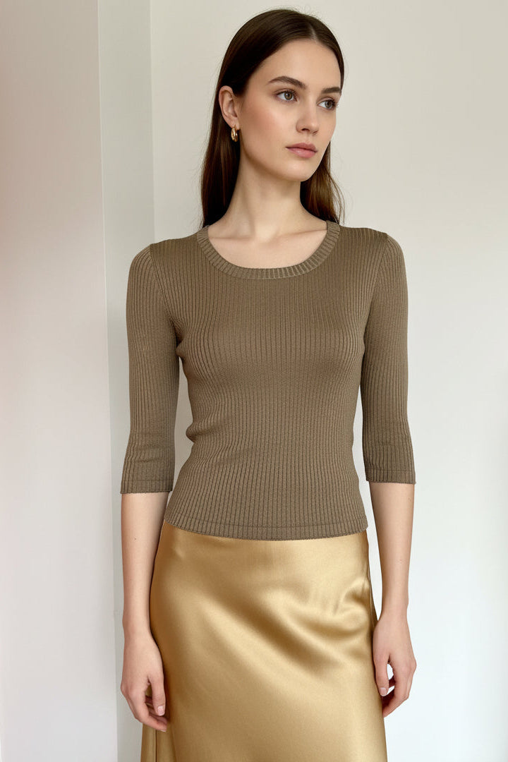 Model wearing a brown ribbed sweater and skirt against a plain background