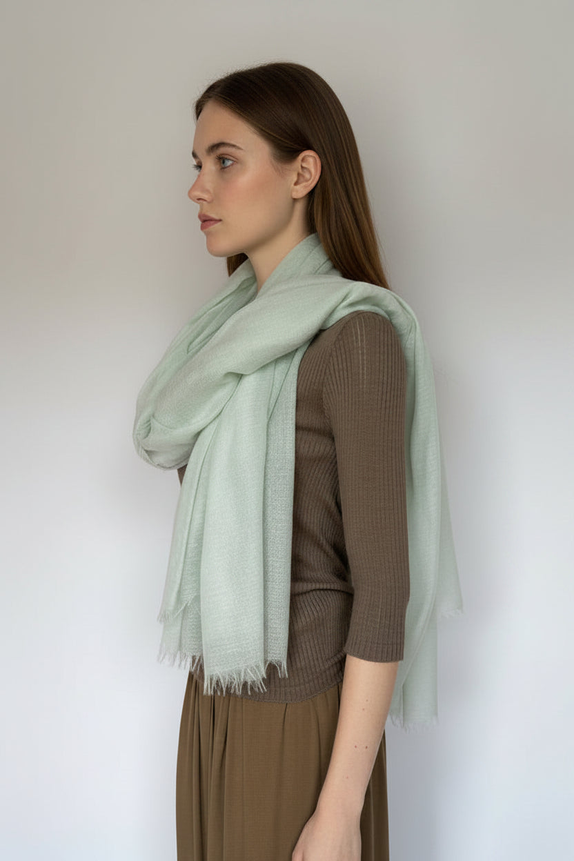 model
wearing a brown outfit with a light green scarf against a plain background