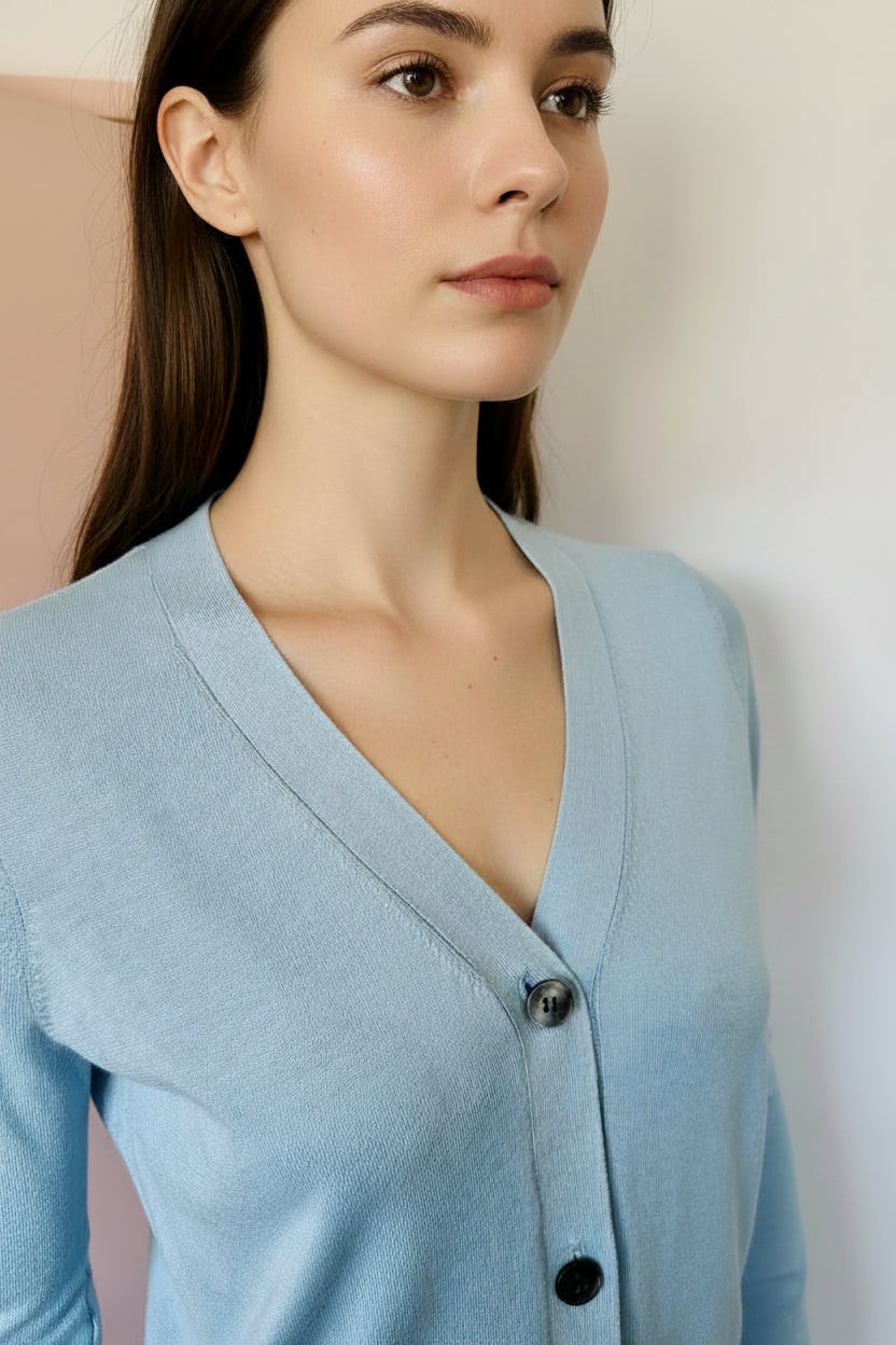 model wearing a light blue cardigan with a plain background