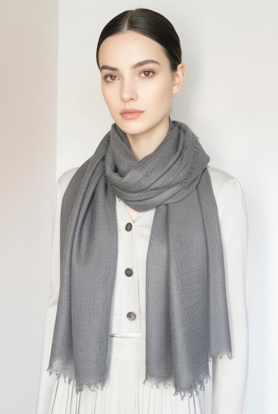 Model wearing a dark gray fine weave cashmere scarf with a plain background