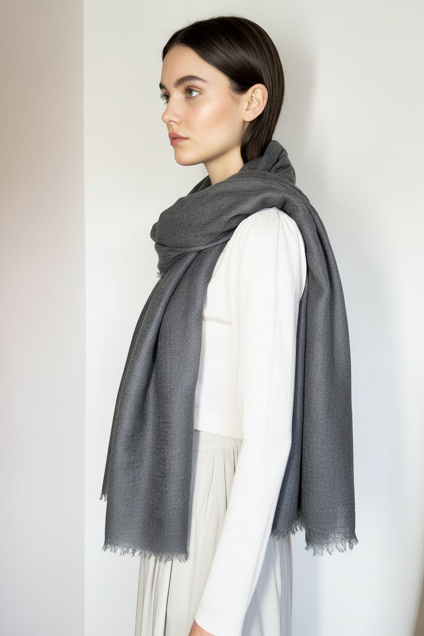 Woman wearing a gray scarf against a plain background