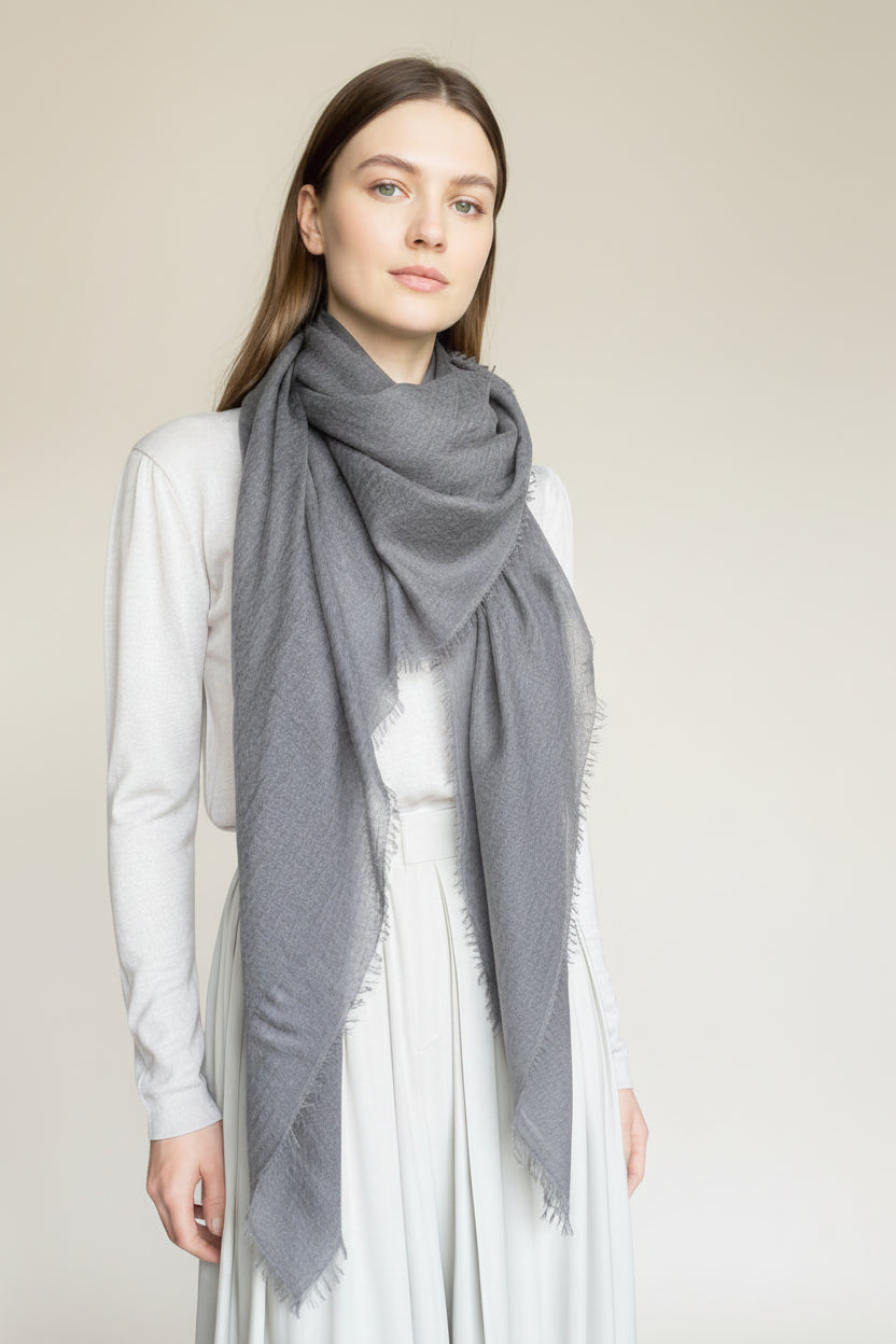 Mannequin wearing a dark gray scarf against a plain background