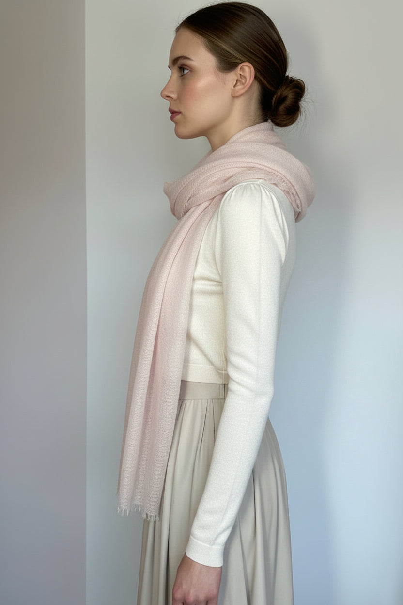 Mannequin wearing a light pink scarf and white outfit against a plain background