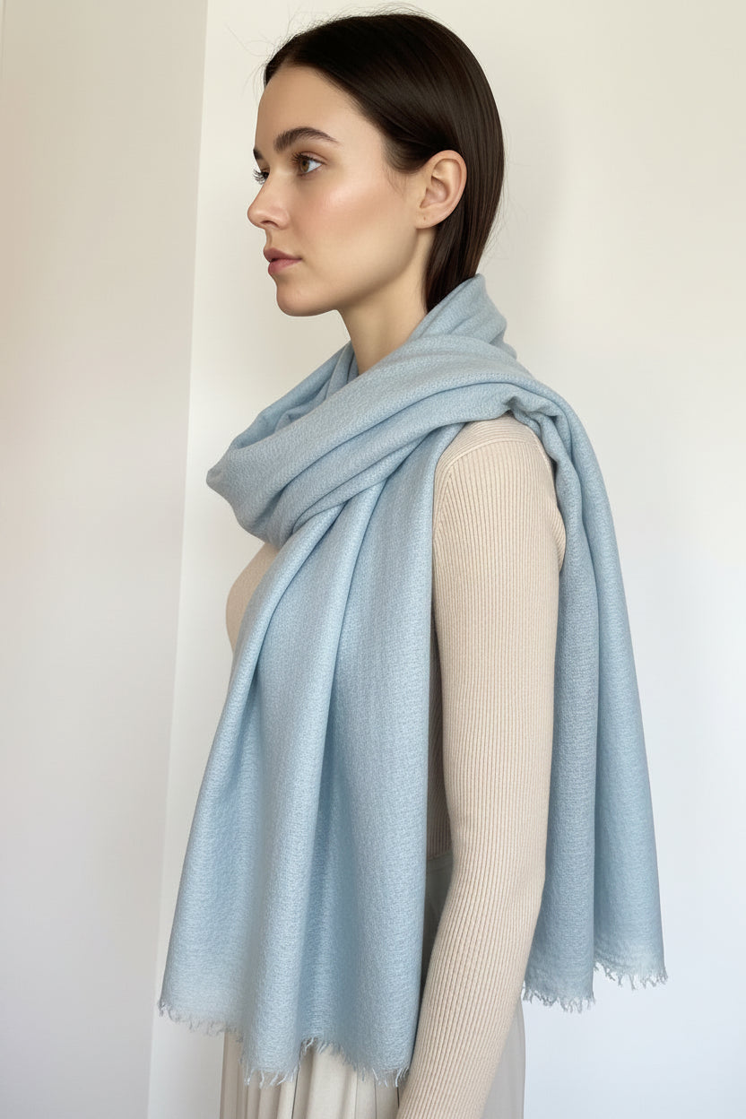 Mannequin wearing a light blue scarf against a neutral background