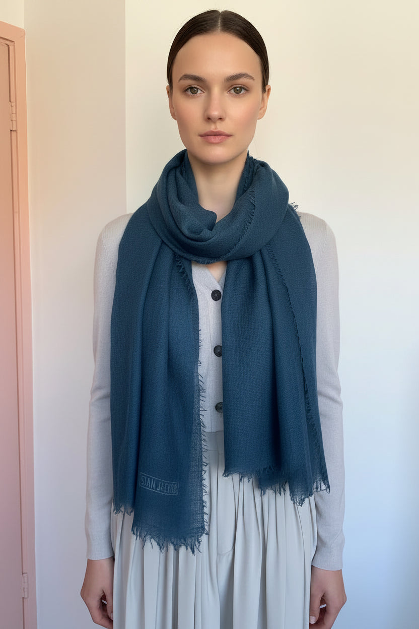 Model wearing a blue scarf with a plain background