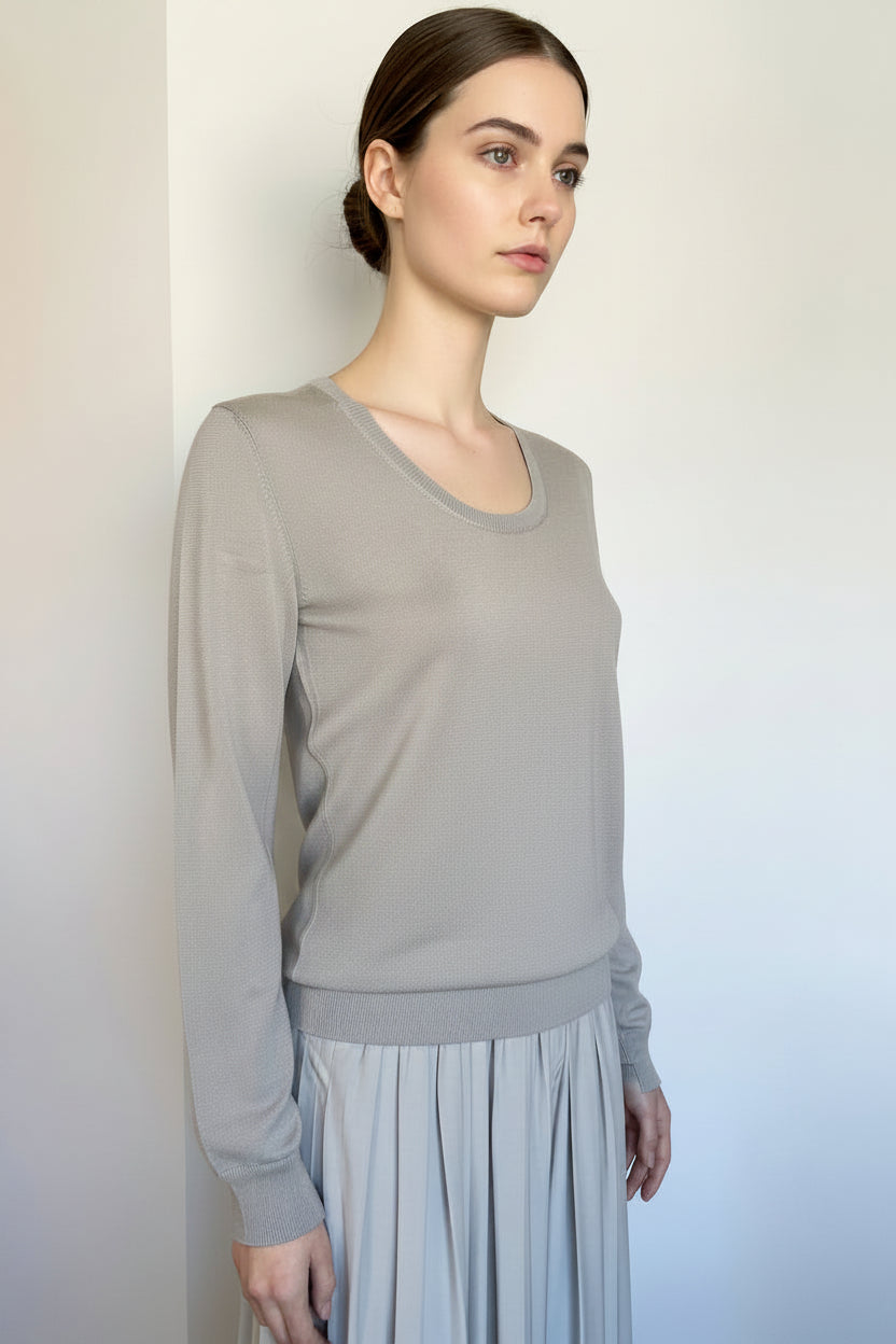 Mannequin wearing a gray pleated dress on a plain background