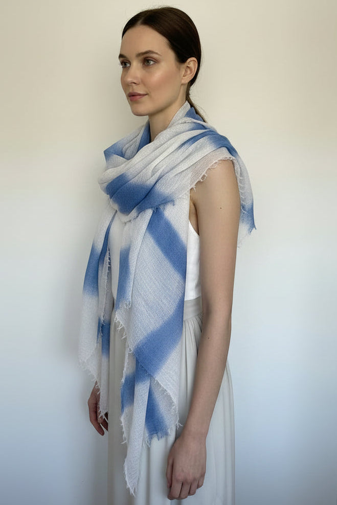 Woman wearing a blue and white striped scarf against a plain background