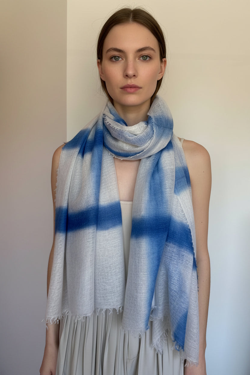 model wearing a gray and blue plaid scarf against a plain background