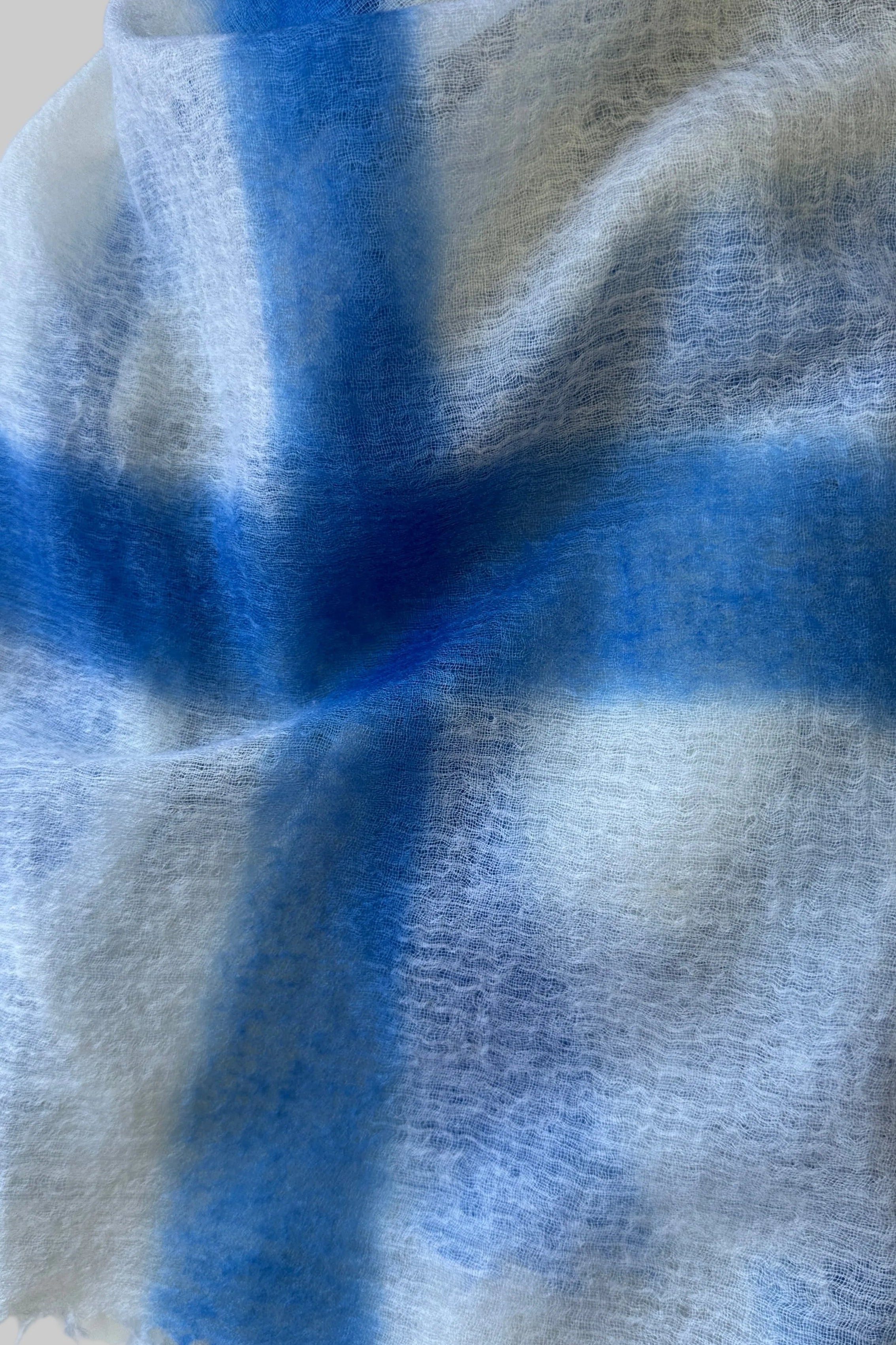 Close-up of a cashmere scarf with blue and white gradient