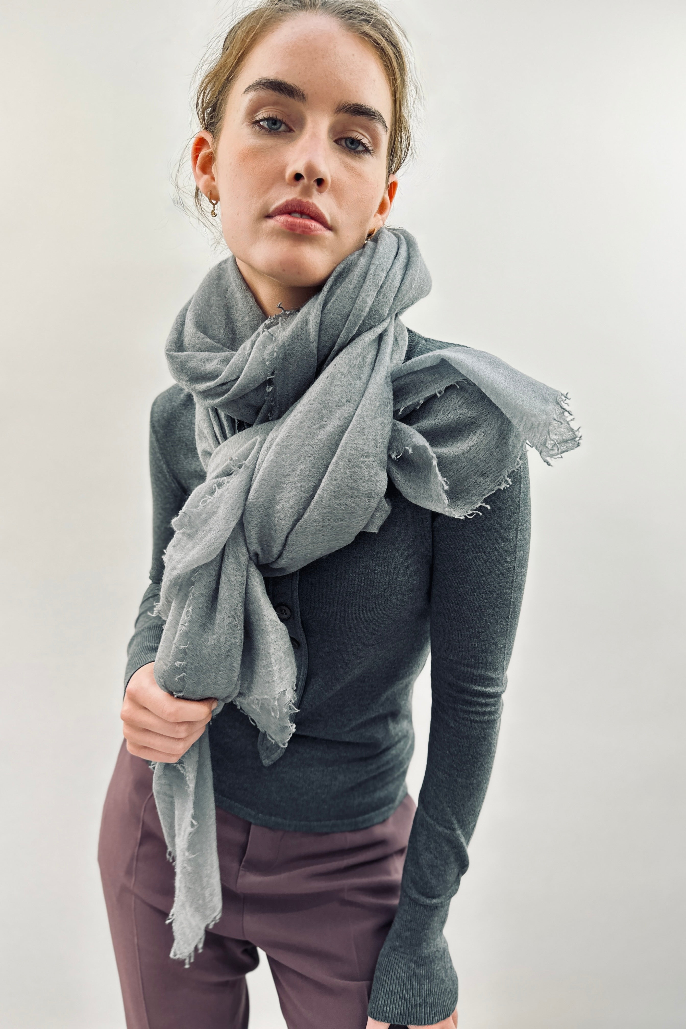 Model wearing a gray marmee cashmere scarf and dark gray sweater against a white background