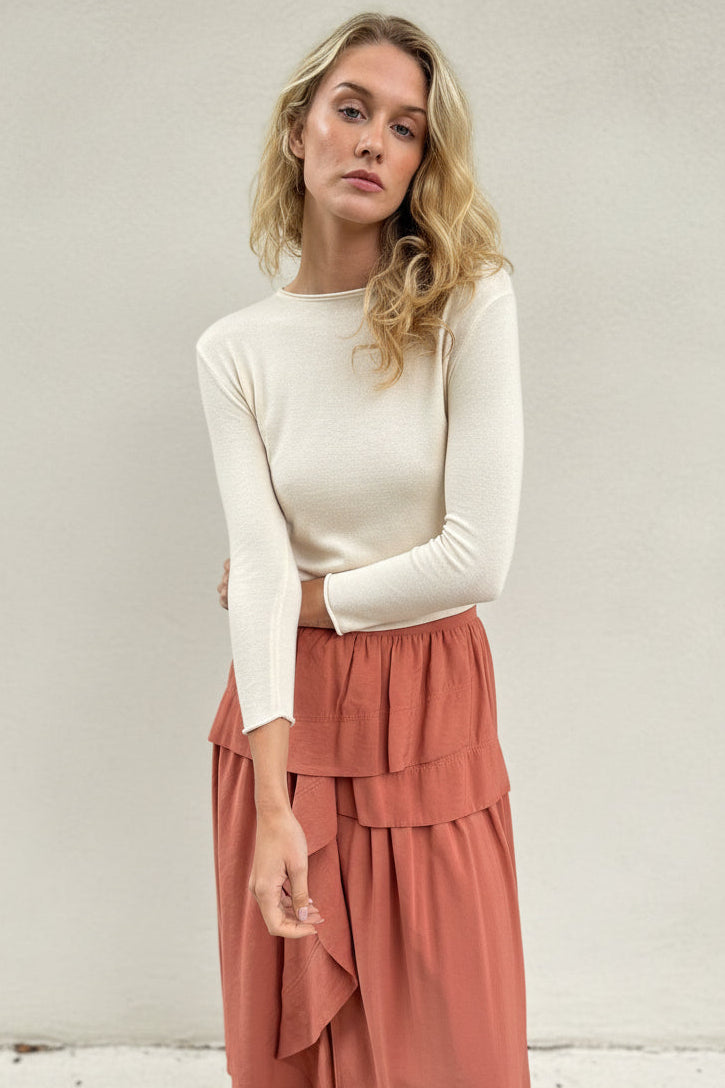 model wearing an ivory cashmere silk top or sweater and pink skirt