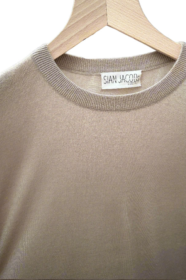 Beige sweater on a hanger with 'Sian Jacob' label against a gray background