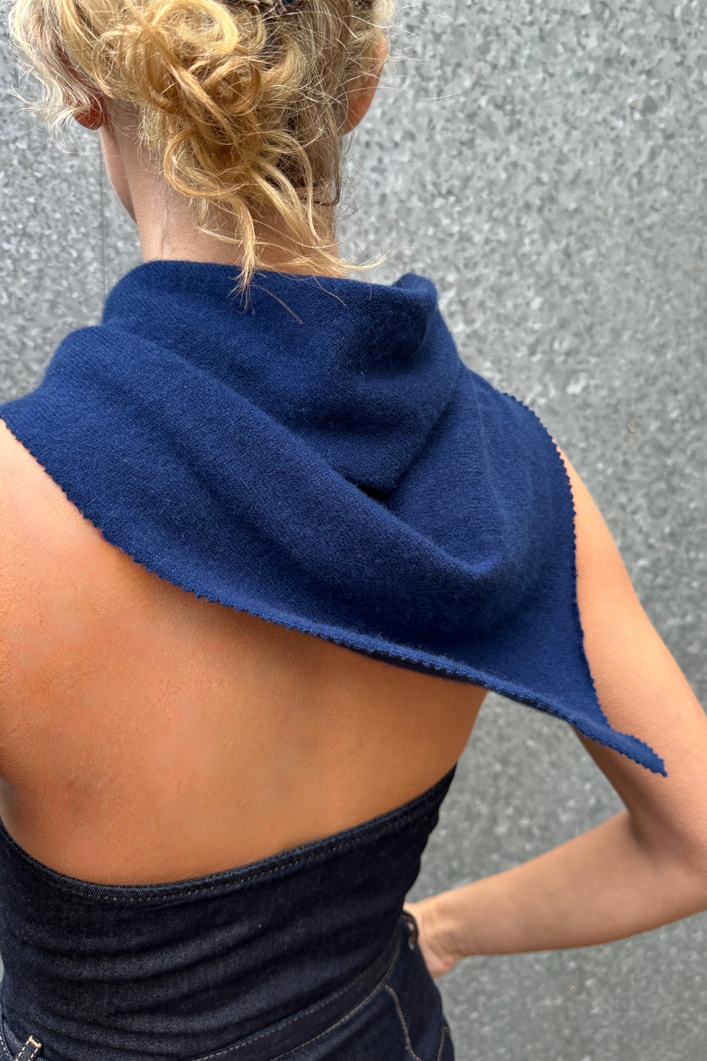 model wearing Doon neck scarf cashmere navy blue scarf over their shoulders against a gray background