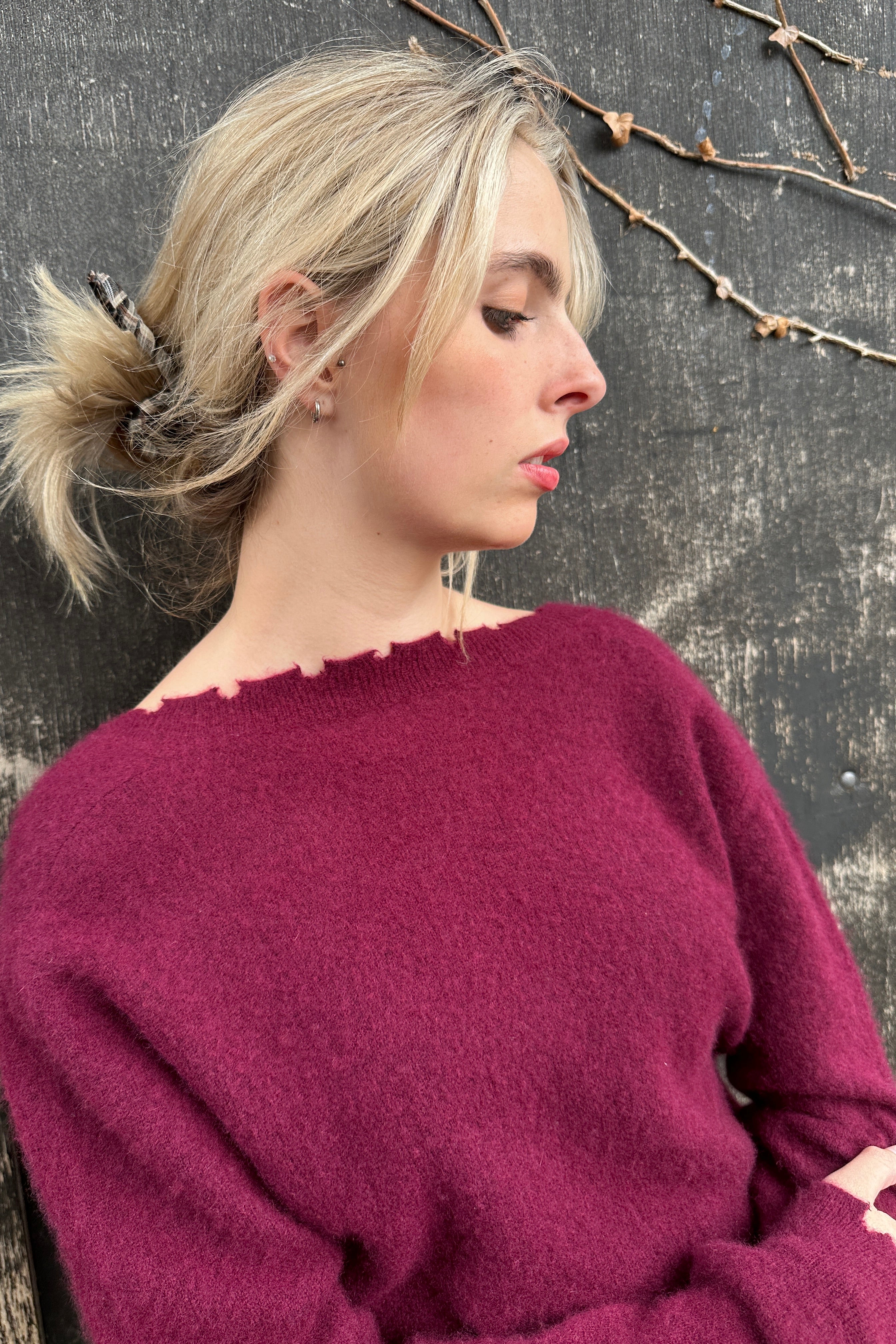 Person wearing a purple sweater on a dark surface