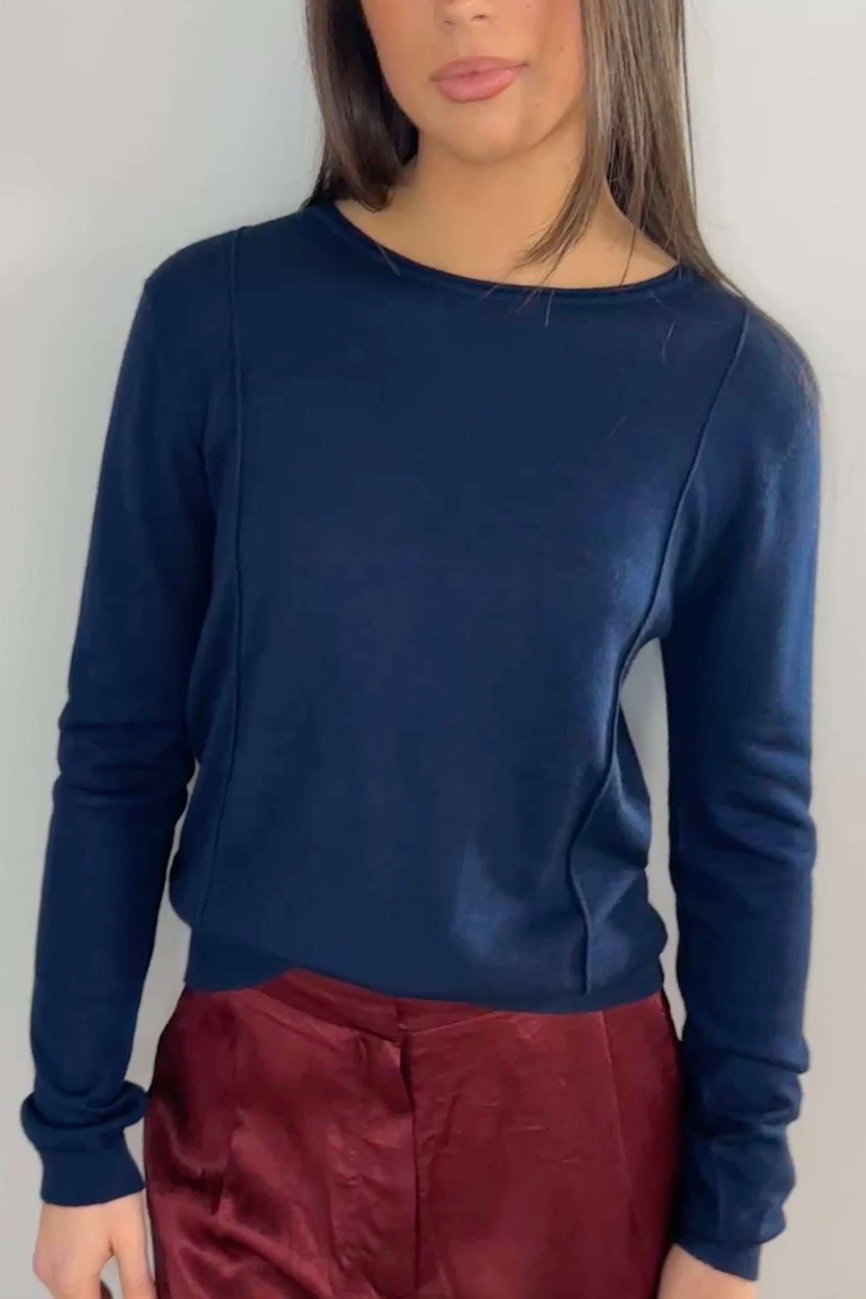 model wearing a navy blue sweater and maroon pants against a plain background Stina navy round neck cashmere silk top