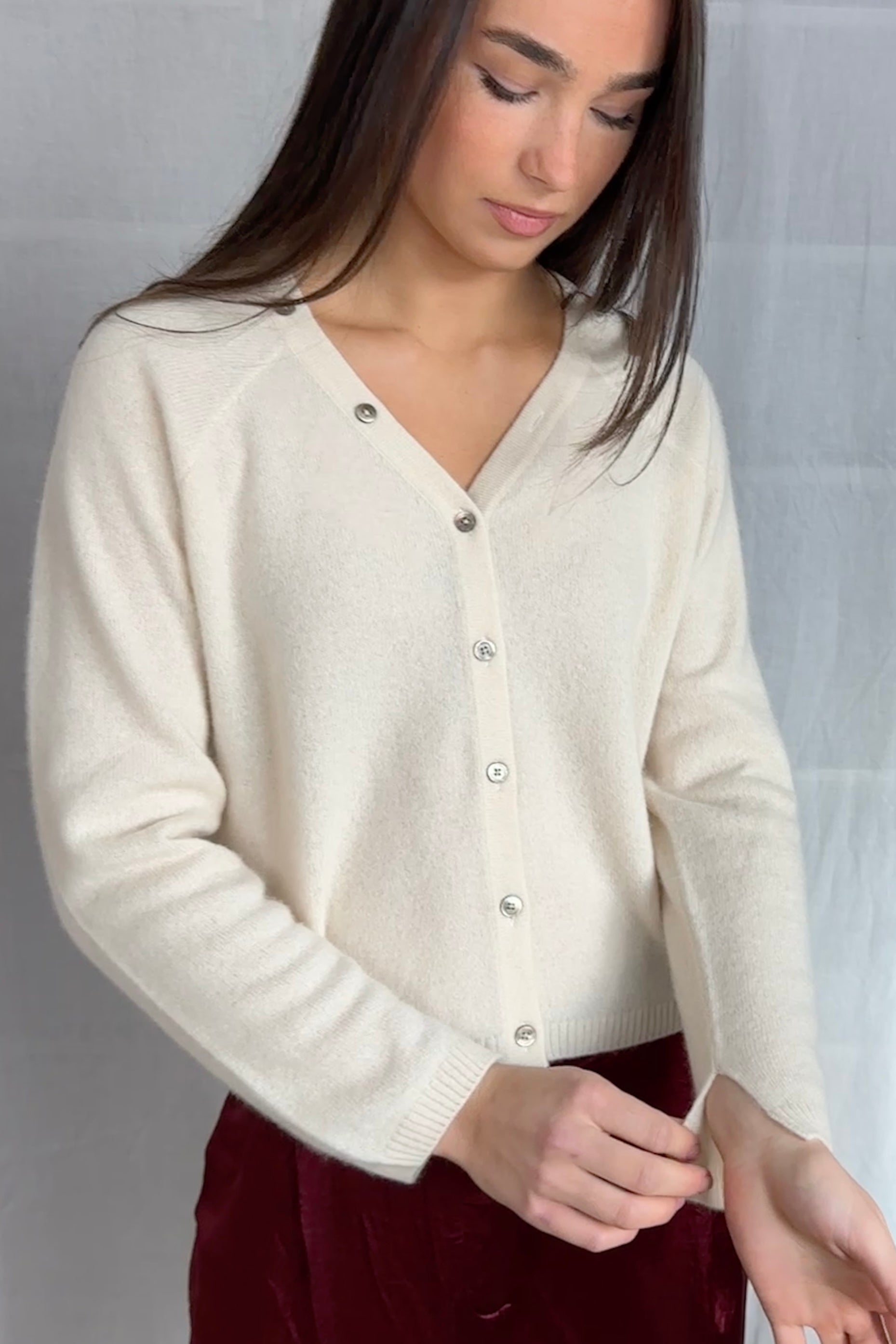 model wearing a cream cashmere cardigan against a plain background ,zelia feather full view