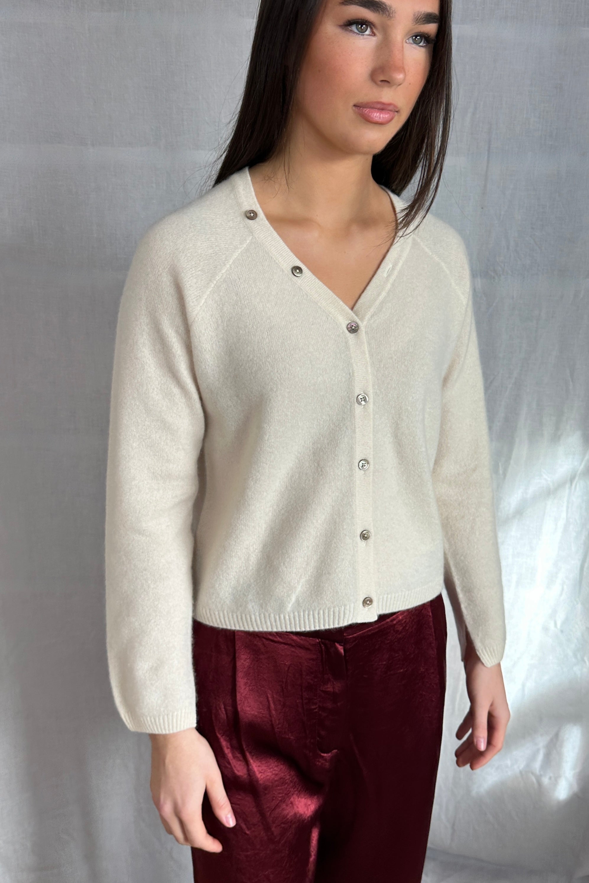model wearing a cream cashmere cardigan against a plain background ,zelia feather 2