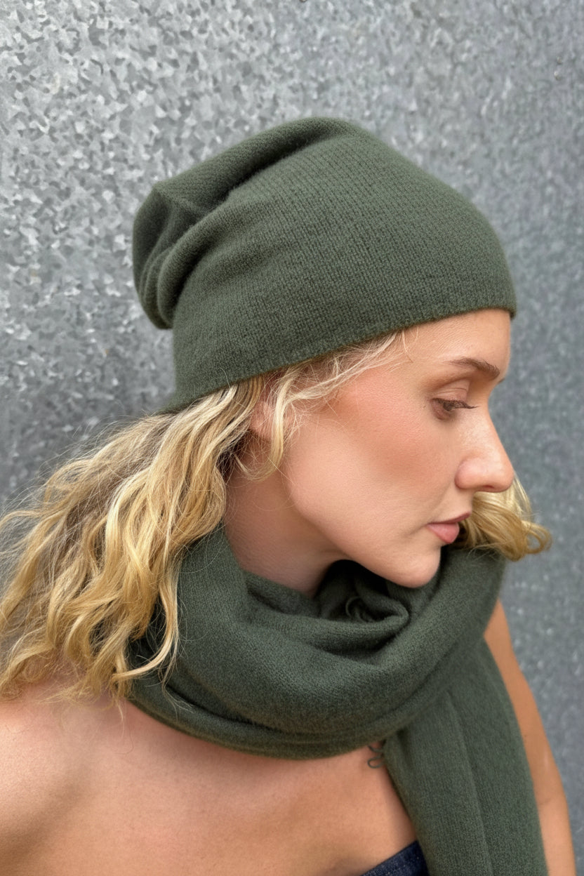 model wearin khaki beanie and scarf against a gray background