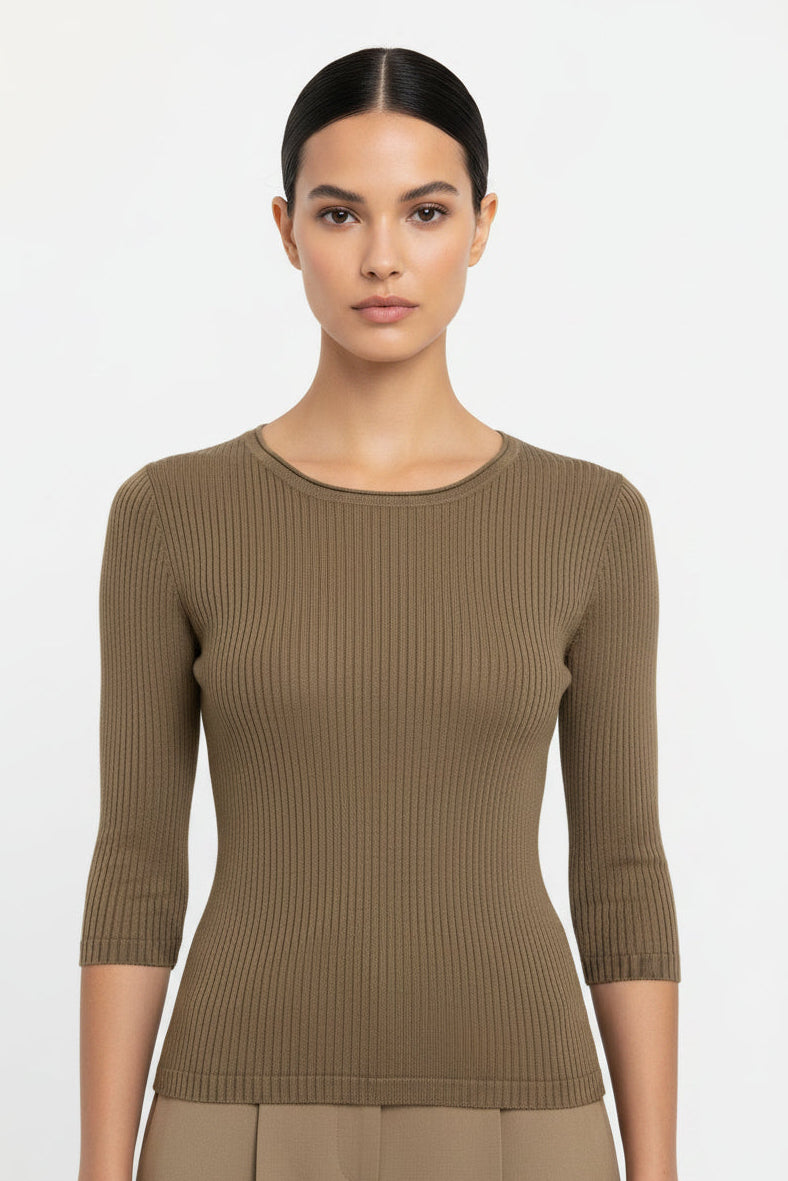 Model wearing a brown ribbed sweater and pants against a plain background