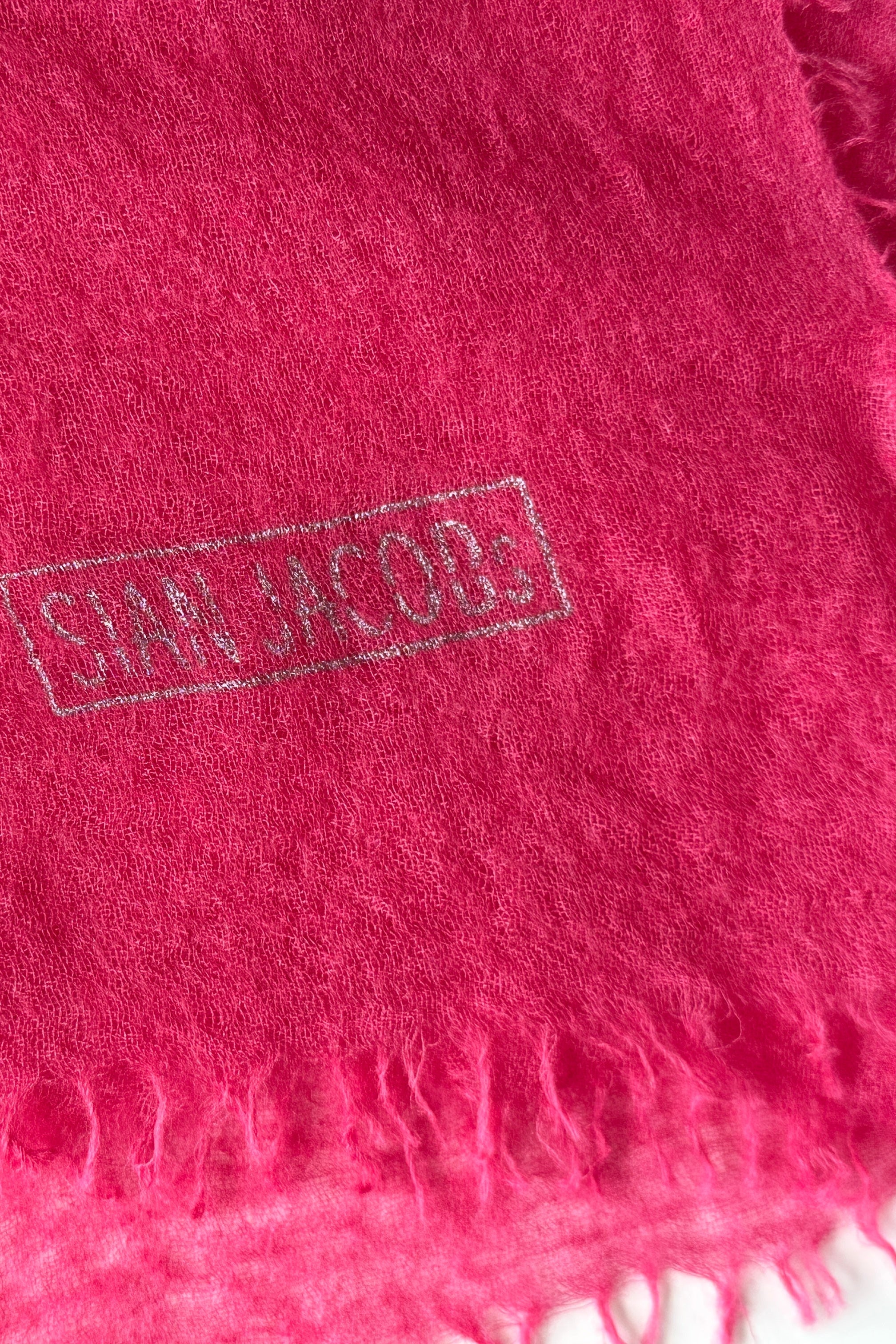 Close-up of a pink cashmere scarf with 'Sian Jacobs' branding.