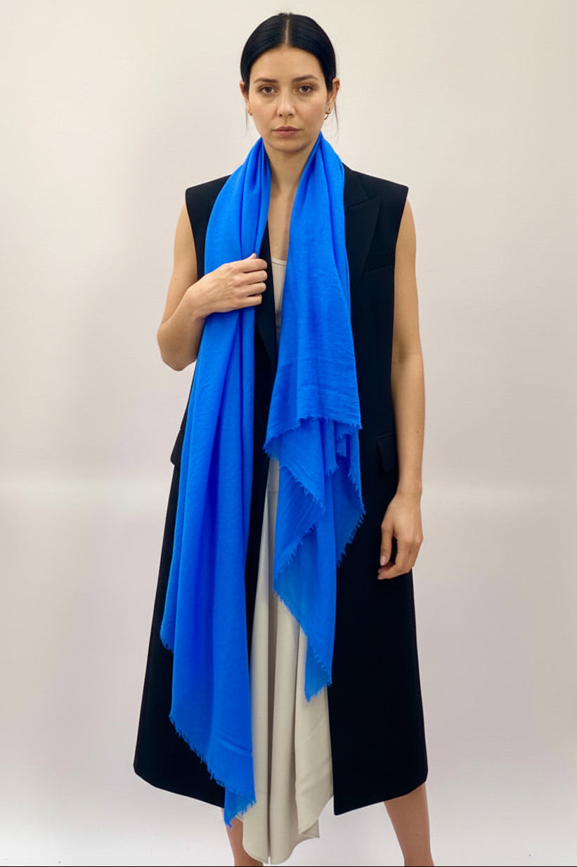 Woman wearing a blue scarf against a plain background