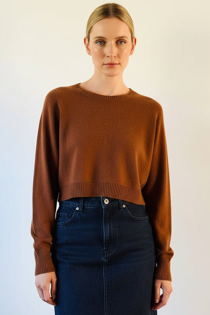 Woman wearing a brown sweater against a light background