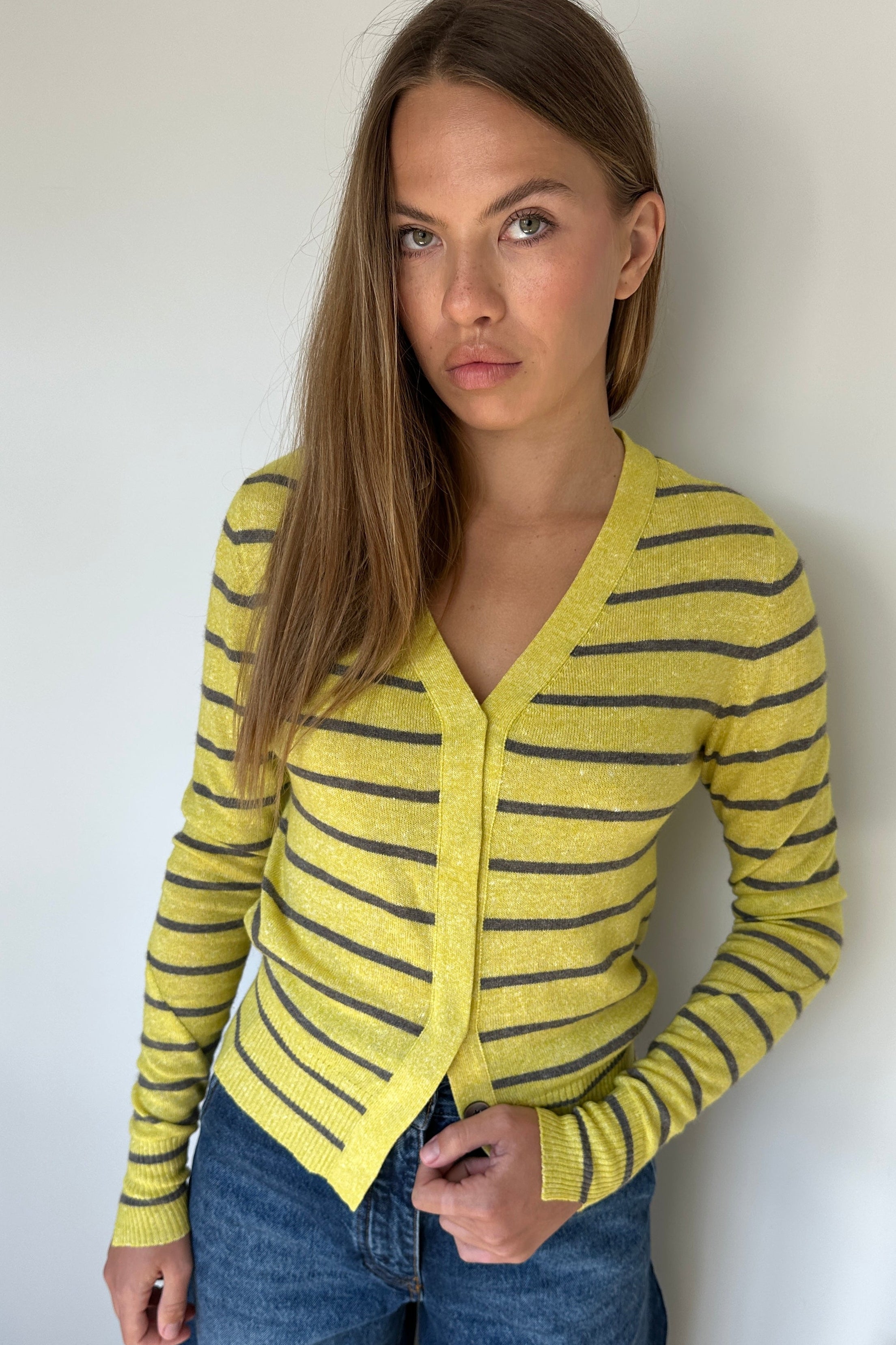 Woman wearing a yellow and black striped sweater against a white background