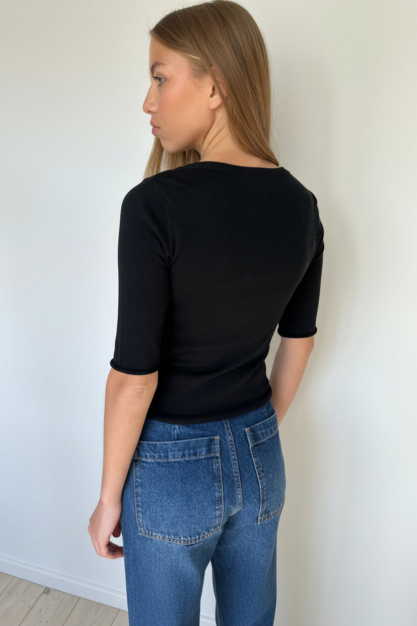 woman in a black top and jeans back view
