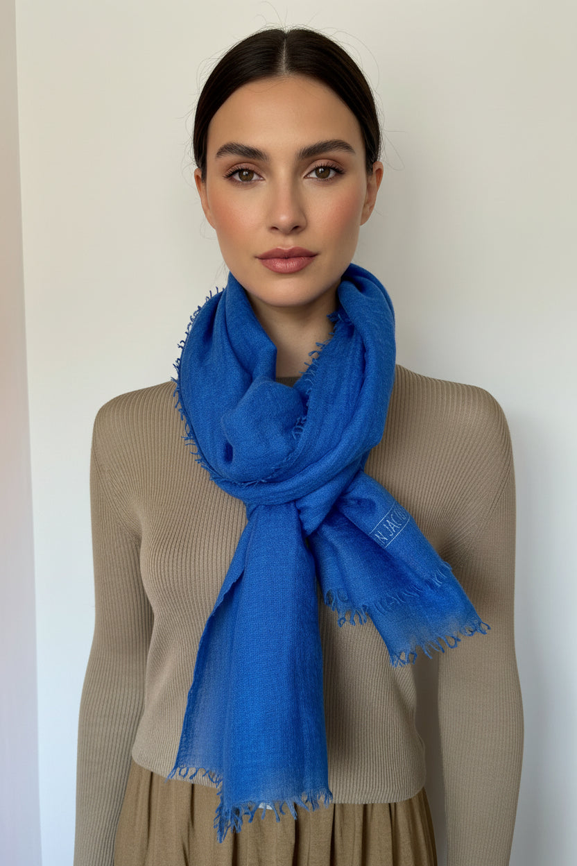 Woman wearing a blue scarf against a plain background