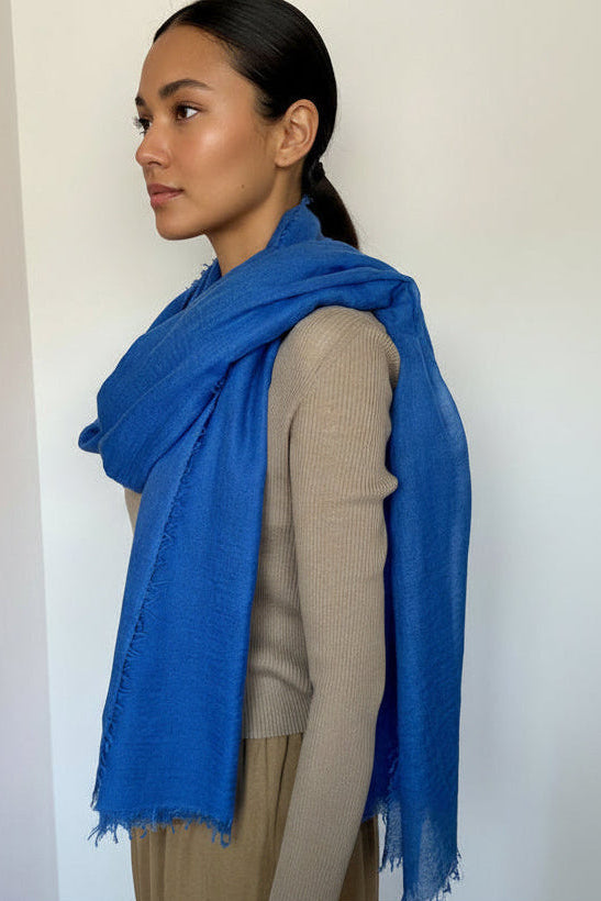 model wearing a marmee cornflower blue scarf with a plain background
