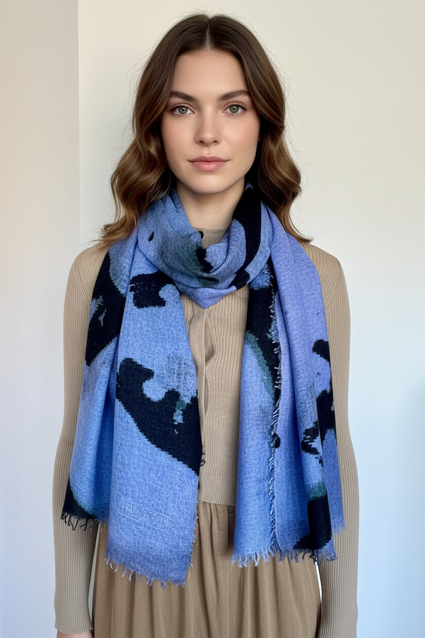 Model wearing a blue scarf with black abstract patterns on a plain background