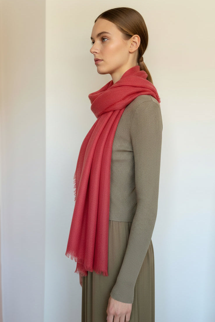 Woman wearing a red scarf  against a plain background