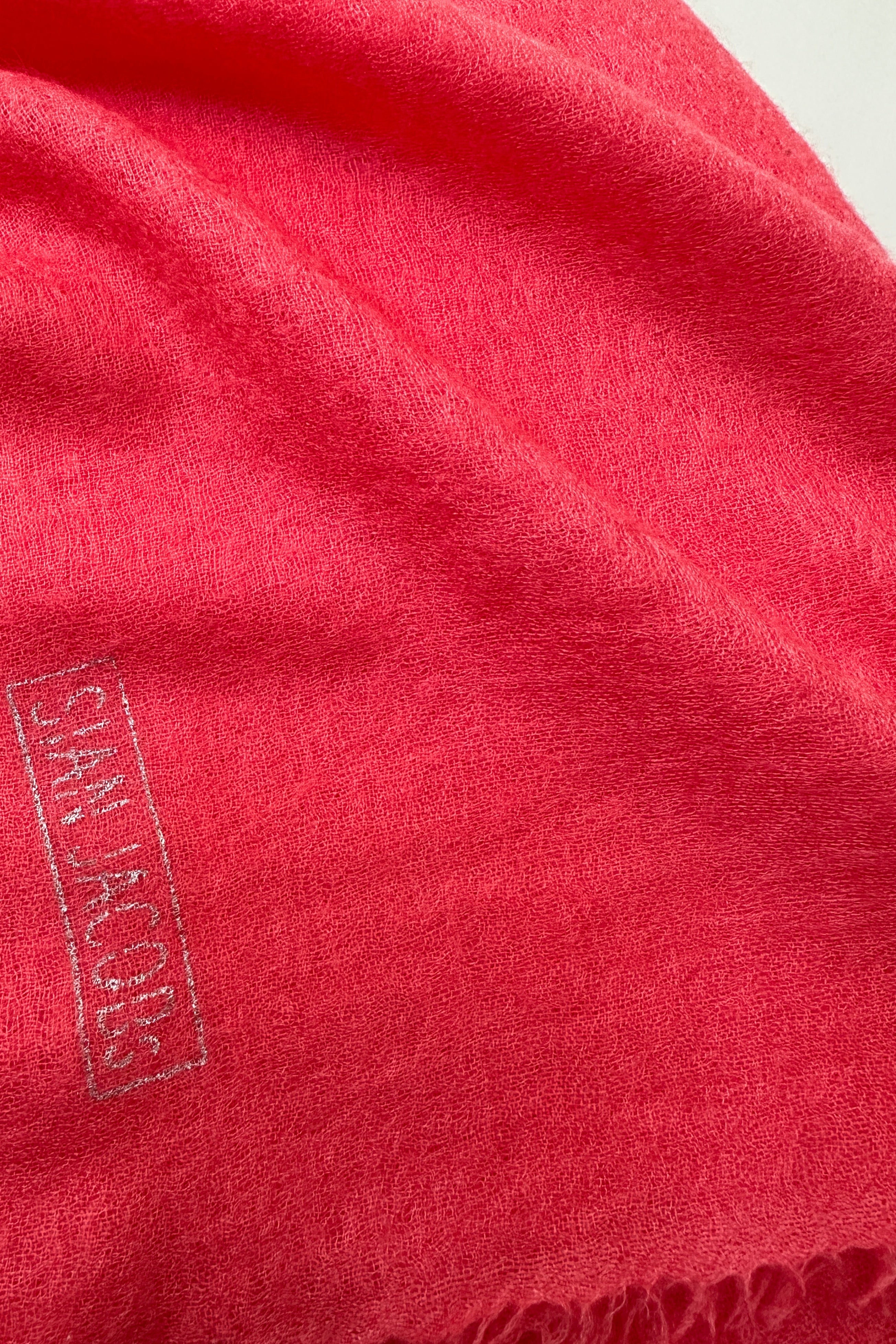 Close-up of a red fabric with 'Sian Jacobs' branding.
