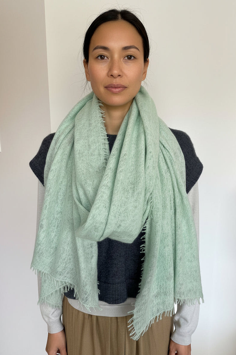 model wearing a green scarf with a plain background