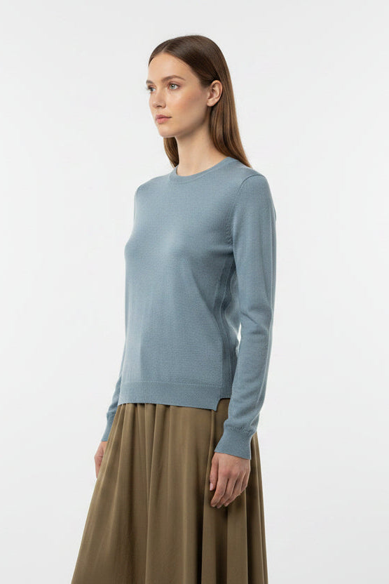 modelwearing a blue gray sweater on a plain background