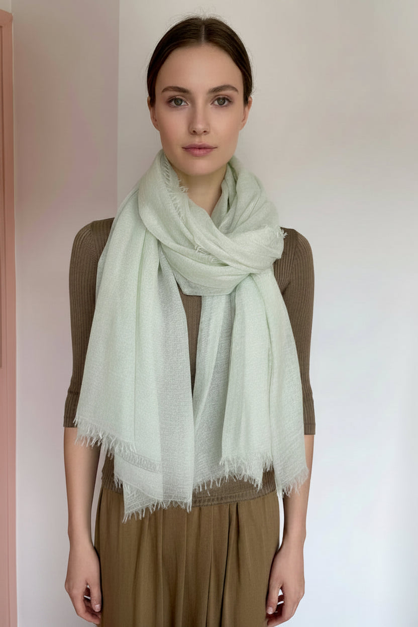 model wearing a light green scarf with a plain background