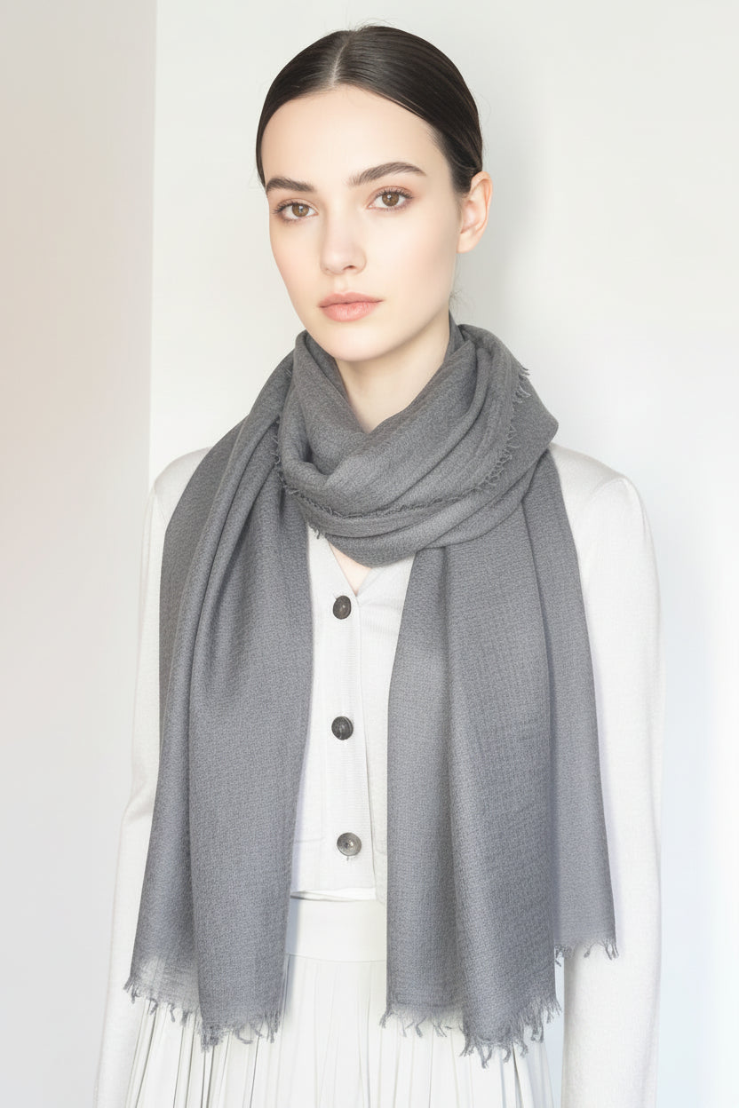 Mannequin wearing a dark gray scarf with a plain background