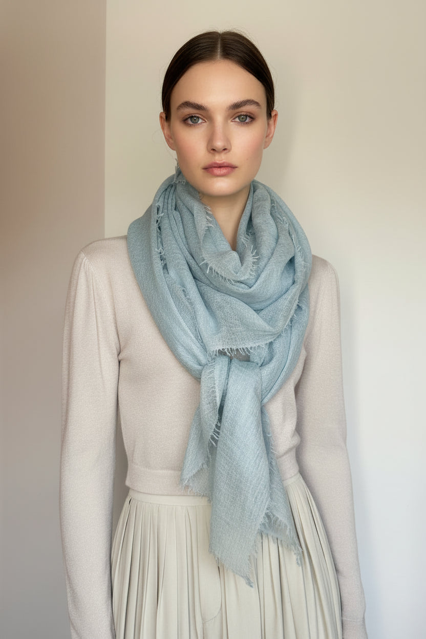 Mannequin wearing a light blue scarf against a plain background