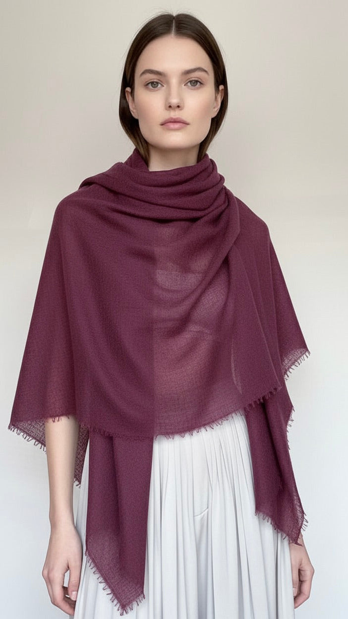 Woman wearing a dark purple scarf on a white background